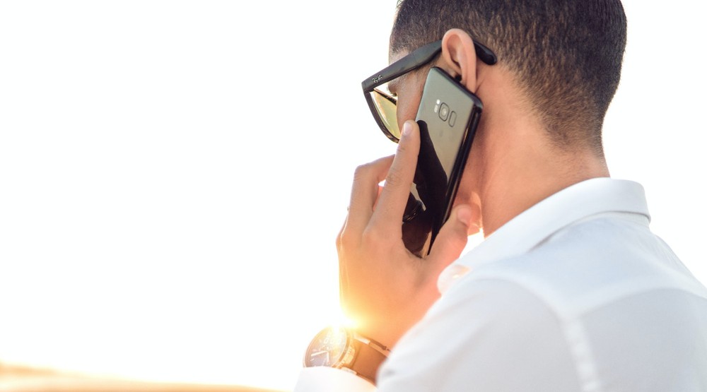 Businessman taking a 1300 phone call on his mobile