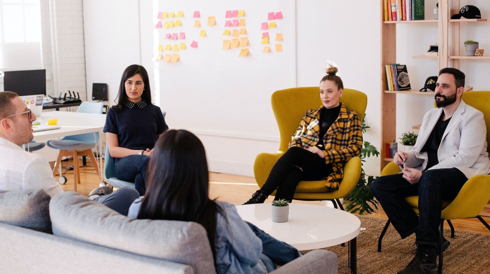 Five people in a casual office environment discussing how to get a 1800 number