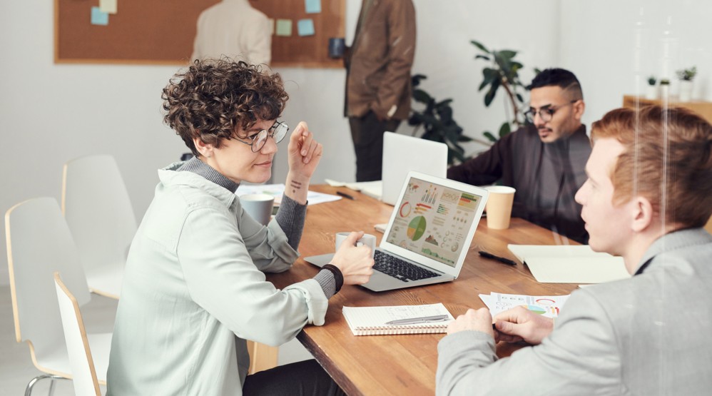 Three young businesspeople discussing the difference between 1300 and 1800 numbers