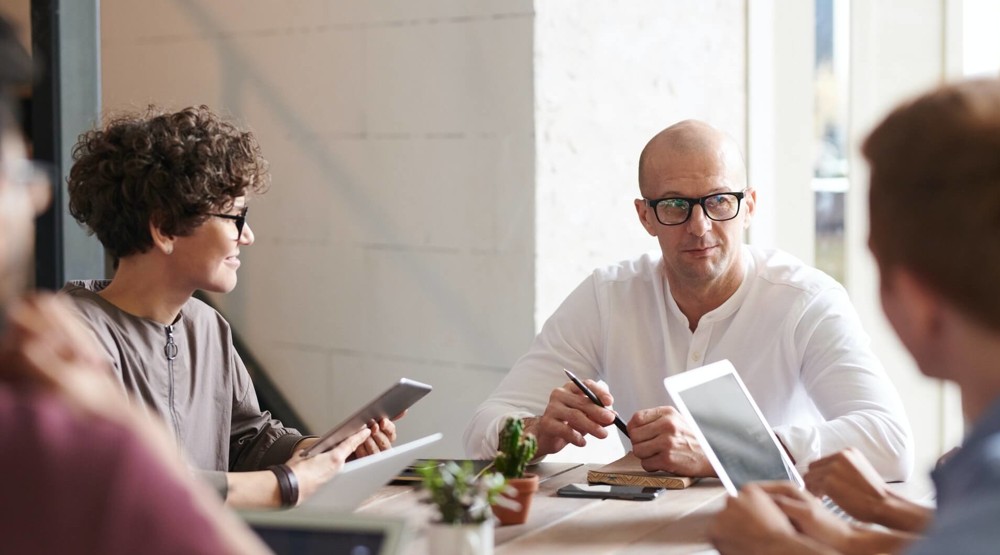 Business meeting with four people discussing how to benefit from a 1300 number