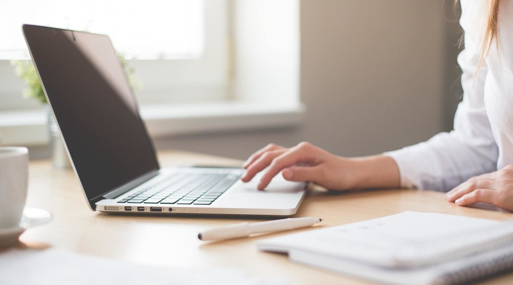 Businesswoman on her laptop choosing a 1300 number plan