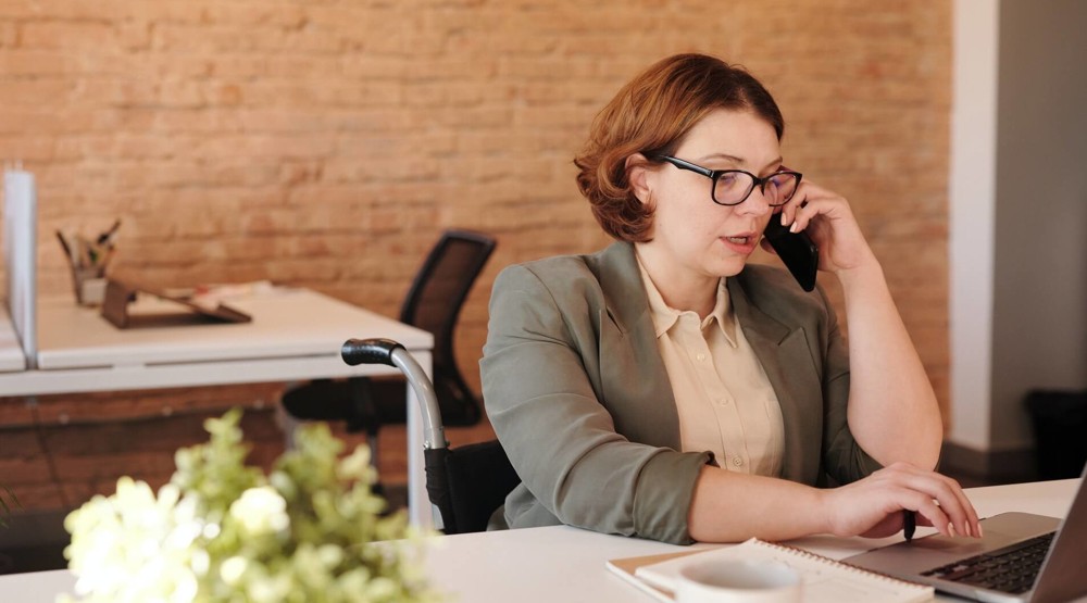 Businesswoman on her mobile asking questions before buying a 1300 phone number