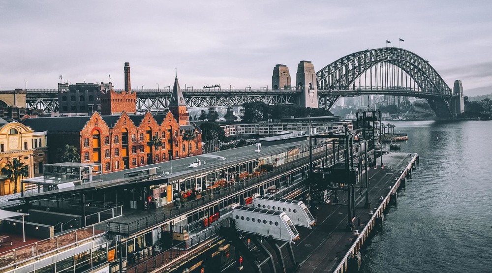 Sydney Harbour Bridge framed by old office buildings using 1300 phone numbers